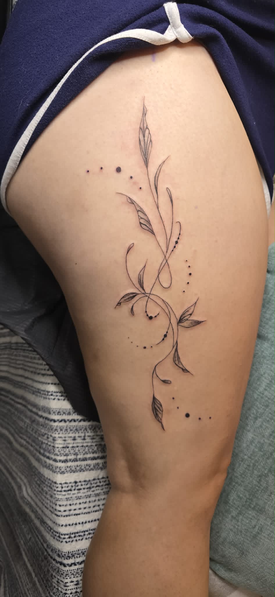 Fine line botanical vine tattoo on thigh