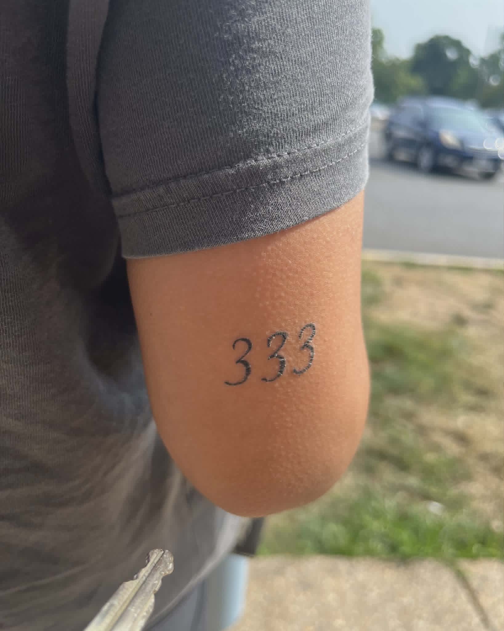 333 lettering tattoo on arm