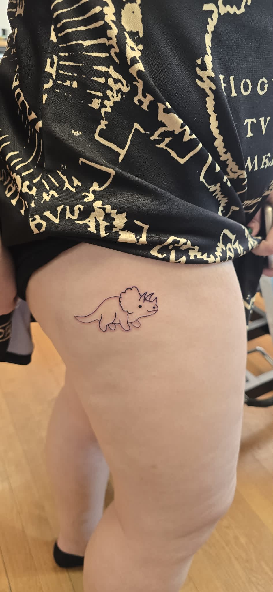 Fine line triceratops dinosaur tattoo on thigh