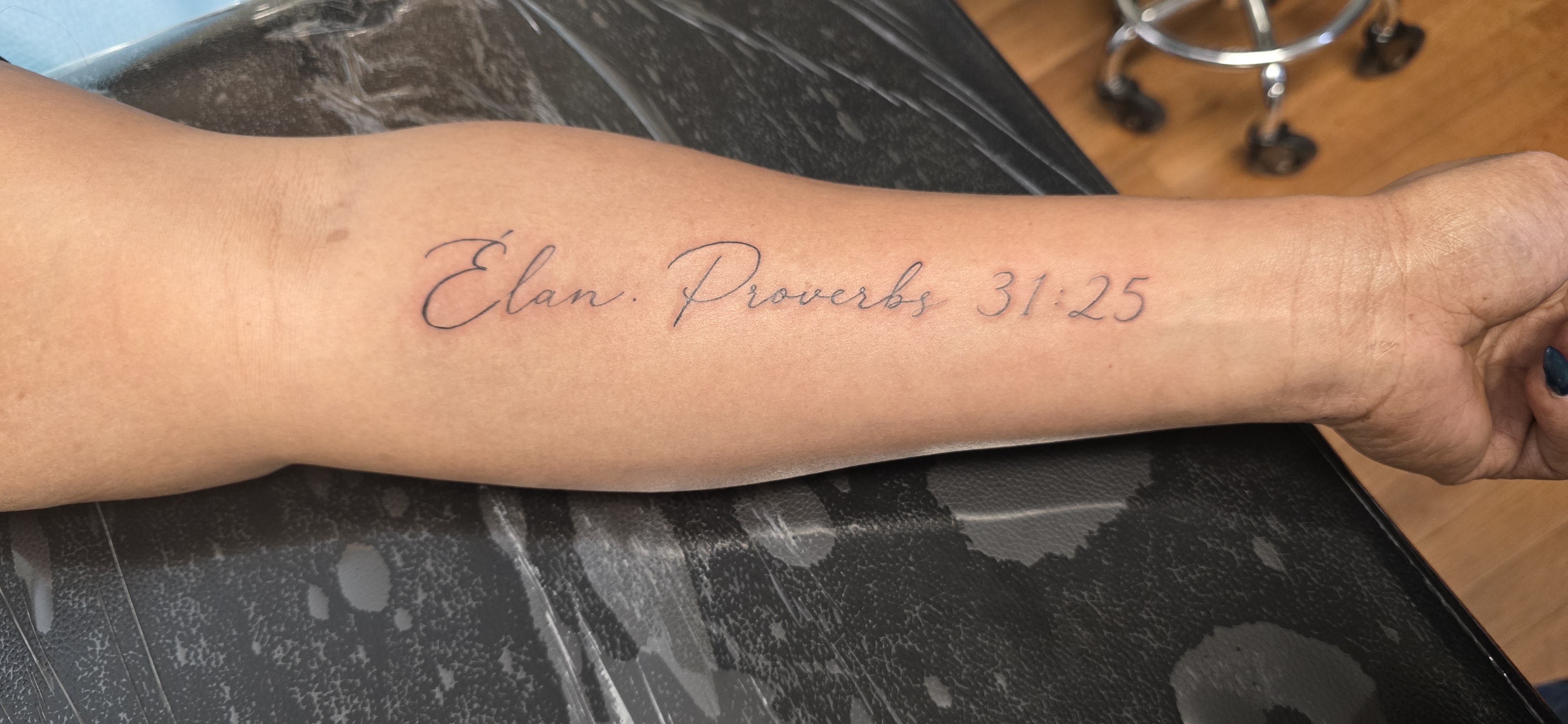 Script lettering tattoo on forearm